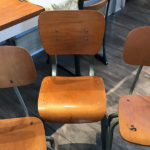 Three empty, old-fashioned school chairs