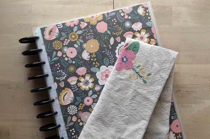 Planner notebook with cleaning cloth folded on top of it.