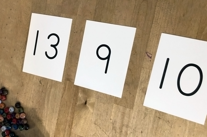 Three number flashcards on a desk for Montessori style lesson