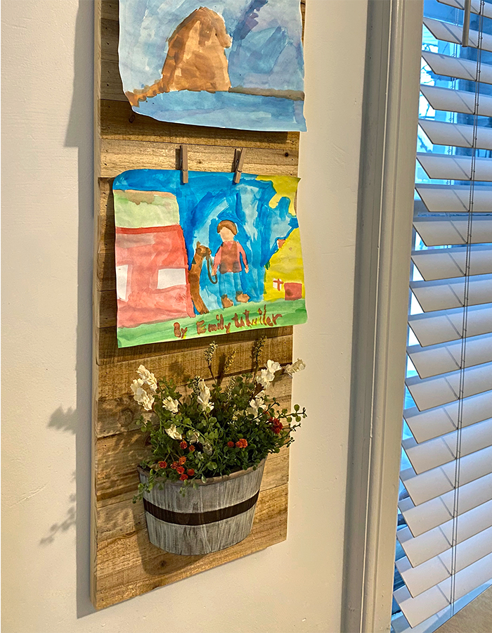 DIY homeschool art display with light wood tones and floral stems
