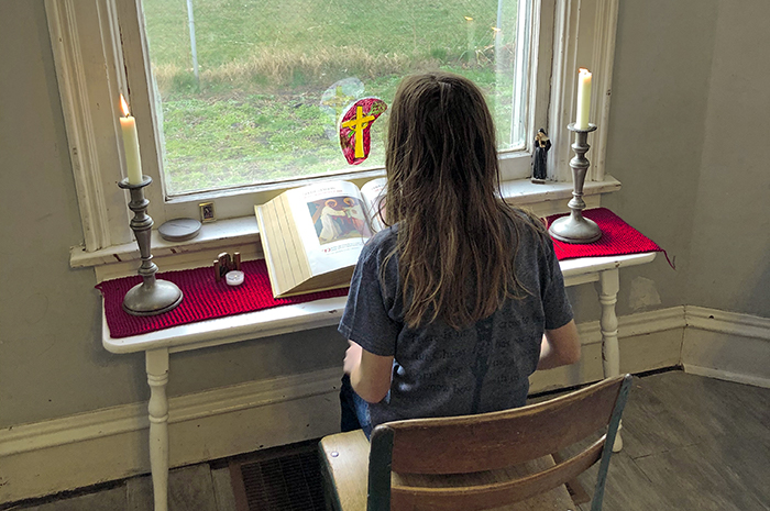 Child at a home prayer table during Lent