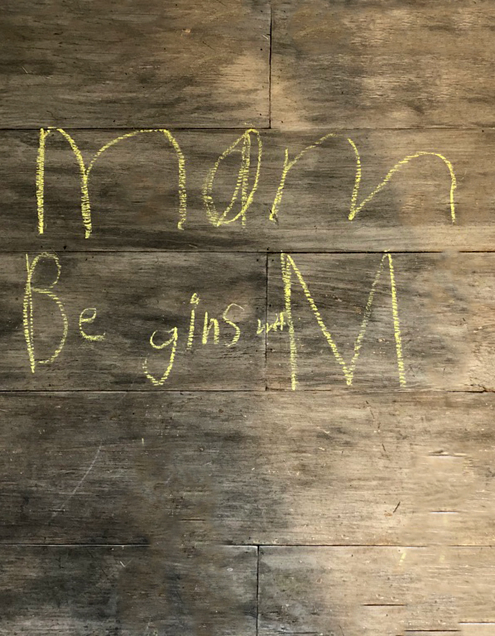 Struggling learner wrote "Mom begins with M" on the floor with sidewalk chalk