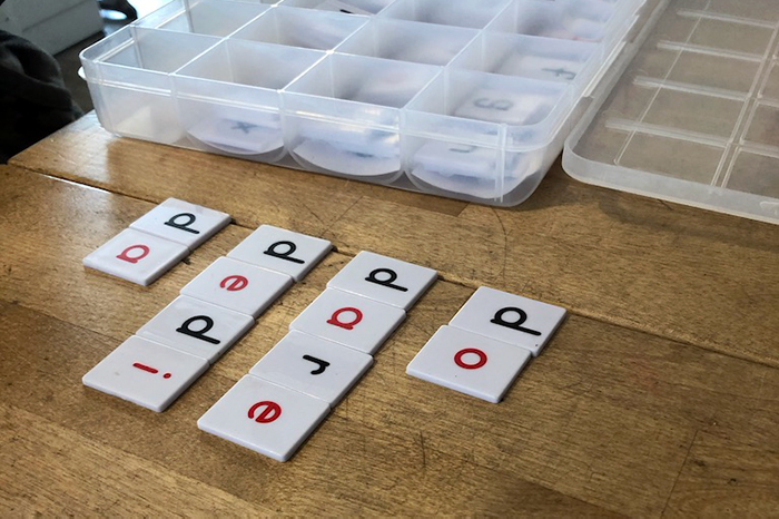 Struggling learner using alphabet tiles to spell Latin words from Memoria Press curriculum